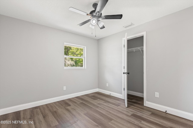 110 Pleasant Dr, East Palatka, FL 32131 - unfurnished bedroom featuring wood finished floors, a closet, ceiling fan, and a walk in closet