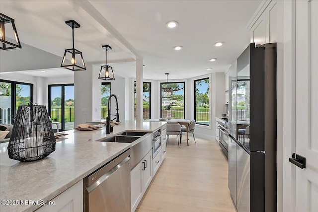172 Laurel Ln, Ponte Vedra Beach, FL 32082 - kitchen with stainless steel appliances, white cabinetry, light stone counters, decorative light fixtures, and recessed lighting