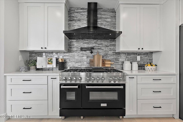 172 Laurel Ln, Ponte Vedra Beach, FL 32082 - kitchen with double oven range, wall chimney exhaust hood, tasteful backsplash, white cabinetry, and light countertops