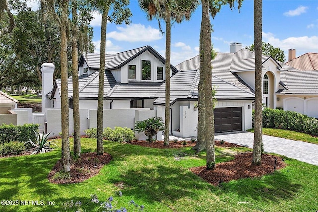172 Laurel Ln, Ponte Vedra Beach, FL 32082 - view of front of house with a chimney, stucco siding, an attached garage, a front lawn, and decorative driveway