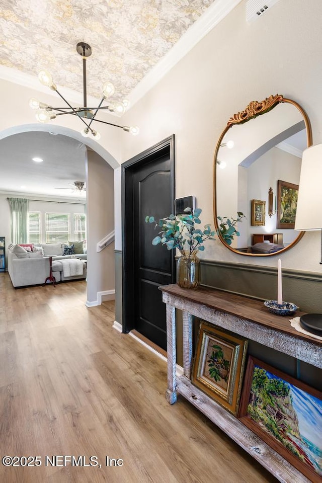 190 Colorado Springs Way, Saint Augustine, FL 32092 - hall with arched walkways, a chandelier, wood finished floors, and ornamental molding
