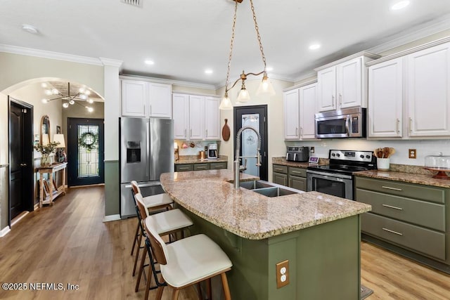 190 Colorado Springs Way, Saint Augustine, FL 32092 - kitchen featuring stainless steel appliances, a kitchen island with sink, arched walkways, crown molding, and white cabinetry