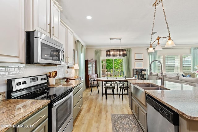 190 Colorado Springs Way, Saint Augustine, FL 32092 - kitchen with appliances with stainless steel finishes, ornamental molding, tasteful backsplash, light wood finished floors, and light stone counters