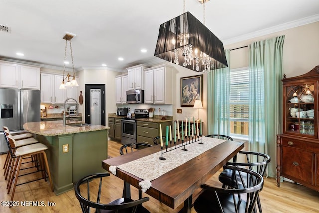 190 Colorado Springs Way, Saint Augustine, FL 32092 - kitchen with appliances with stainless steel finishes, a chandelier, ornamental molding, light wood-type flooring, and white cabinets