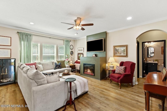 190 Colorado Springs Way, Saint Augustine, FL 32092 - living area with ceiling fan, arched walkways, light wood-style floors, a glass covered fireplace, and crown molding