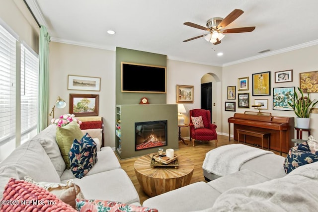 190 Colorado Springs Way, Saint Augustine, FL 32092 - living area featuring arched walkways, a ceiling fan, ornamental molding, a glass covered fireplace, and wood finished floors
