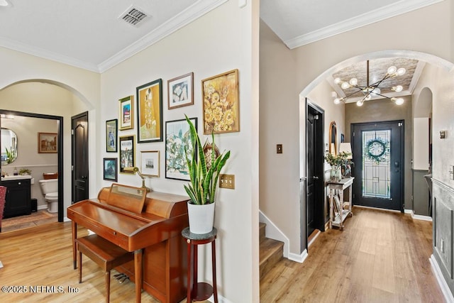 190 Colorado Springs Way, Saint Augustine, FL 32092 - foyer featuring arched walkways, ornamental molding, light wood-type flooring, and a chandelier