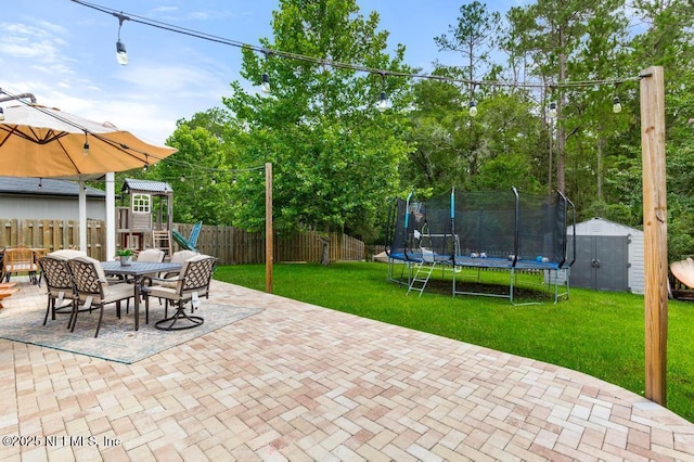 190 Colorado Springs Way, Saint Augustine, FL 32092 - fenced backyard featuring a trampoline, a shed, a patio area, outdoor dining space, and a playground