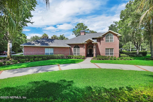 101 Royal Lagoon Ct, Ponte Vedra Beach, FL 32082 - view of front of property featuring a chimney, a front yard, and brick siding