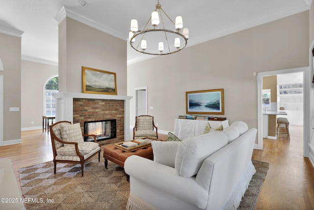 101 Royal Lagoon Ct, Ponte Vedra Beach, FL 32082 - living room featuring crown molding, light wood-type flooring, a chandelier, and a brick fireplace