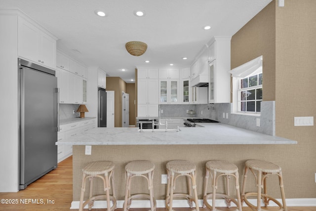 101 Royal Lagoon Ct, Ponte Vedra Beach, FL 32082 - kitchen with high end refrigerator, a peninsula, white cabinetry, backsplash, and recessed lighting