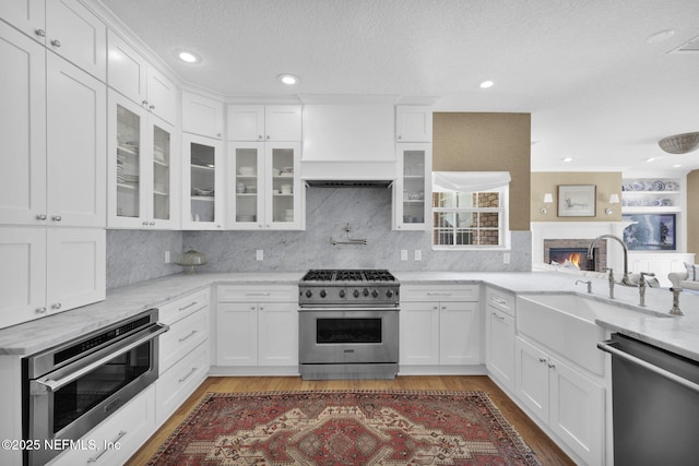 101 Royal Lagoon Ct, Ponte Vedra Beach, FL 32082 - kitchen with stainless steel appliances, premium range hood, white cabinets, glass insert cabinets, and recessed lighting