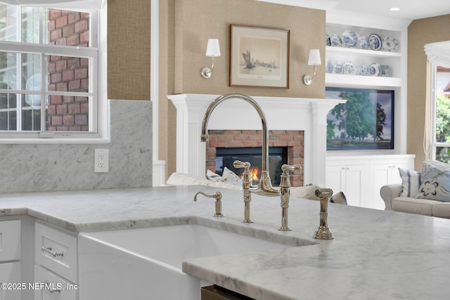 101 Royal Lagoon Ct, Ponte Vedra Beach, FL 32082 - kitchen featuring light stone countertops, a brick fireplace, and white cabinetry
