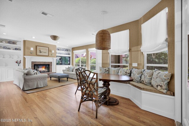 101 Royal Lagoon Ct, Ponte Vedra Beach, FL 32082 - dining space with wood finished floors, a fireplace, built in shelves, and a textured ceiling