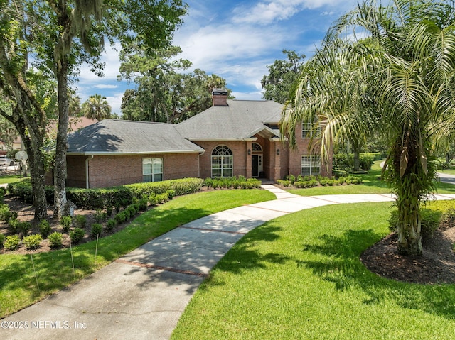 101 Royal Lagoon Ct, Ponte Vedra Beach, FL 32082 - view of front facade featuring brick siding, a front lawn, a chimney, and a shingled roof