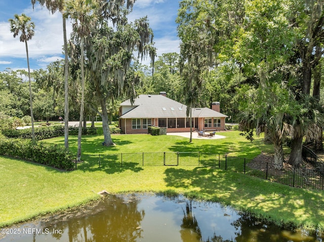 101 Royal Lagoon Ct, Ponte Vedra Beach, FL 32082 - rear view of property with a chimney, a fenced backyard, a patio area, a water view, and a sunroom