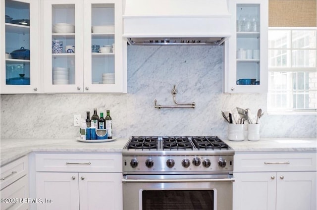 101 Royal Lagoon Ct, Ponte Vedra Beach, FL 32082 - kitchen featuring high end range, premium range hood, white cabinetry, decorative backsplash, and glass insert cabinets