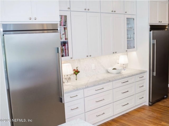 101 Royal Lagoon Ct, Ponte Vedra Beach, FL 32082 - kitchen with high quality fridge, white cabinetry, and glass insert cabinets