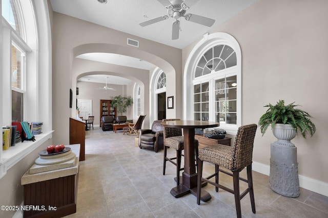 2525 College St Unit 1305, Jacksonville, FL 32204 - dining room featuring ceiling fan, arched walkways, light tile patterned floors, plenty of natural light, and a textured ceiling