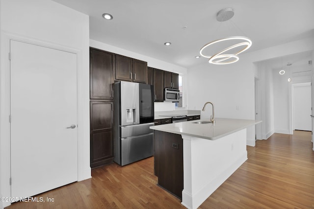 2525 College St Unit 1305, Jacksonville, FL 32204 - kitchen featuring appliances with stainless steel finishes, a chandelier, light wood-style flooring, dark brown cabinetry, and light countertops