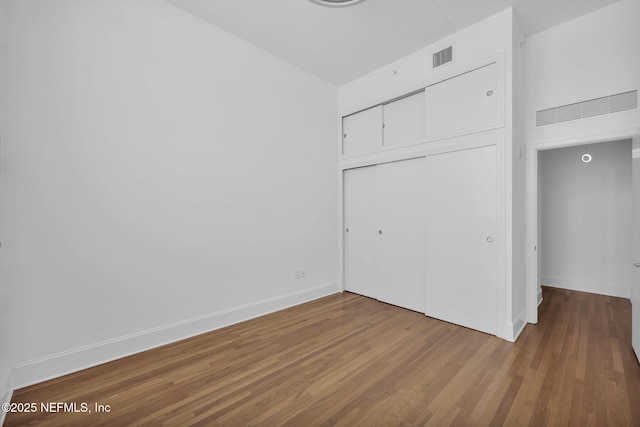 2525 College St Unit 1305, Jacksonville, FL 32204 - unfurnished bedroom with wood finished floors and a closet