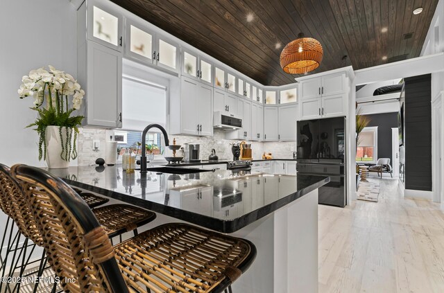 74 Sanford St, Saint Augustine, FL 32084 - kitchen with freestanding refrigerator, ventilation hood, a peninsula, wood ceiling, and dark countertops