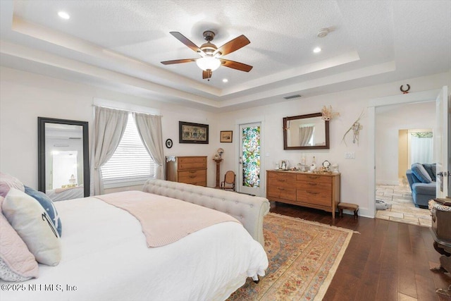 3776 Arrowhead Dr, Saint Augustine, FL 32086 - bedroom featuring a tray ceiling, dark wood-style floors, a ceiling fan, recessed lighting, and a textured ceiling