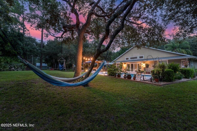 3776 Arrowhead Dr, Saint Augustine, FL 32086 - yard at dusk featuring a lawn, a playground, and an outdoor pool