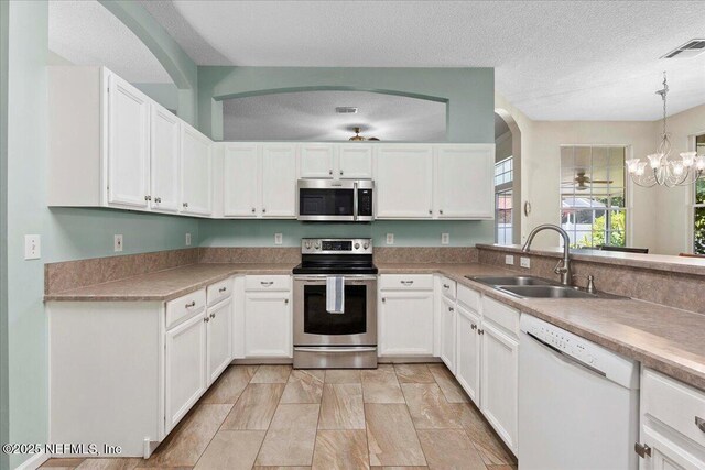 573 N Bridgestone Ave, Saint Johns, FL 32259 - kitchen with stainless steel appliances, white cabinetry, a textured ceiling, light countertops, and hanging light fixtures