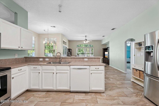 573 N Bridgestone Ave, Saint Johns, FL 32259 - kitchen featuring appliances with stainless steel finishes, a peninsula, ceiling fan, white cabinetry, and decorative light fixtures