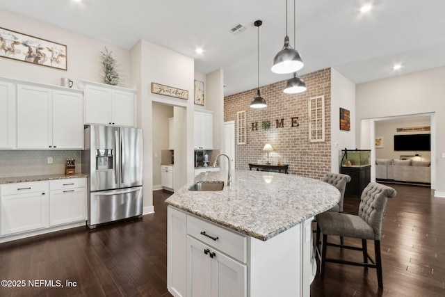 36501 Shortleaf Ave, Hilliard, FL 32046 - kitchen featuring stainless steel refrigerator with ice dispenser, dark wood finished floors, decorative backsplash, white cabinetry, and light stone counters