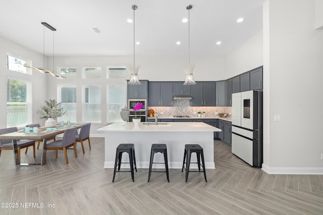 238 Courtney Chase Dr, Saint Augustine, FL 32092 - kitchen with refrigerator, light countertops, stainless steel gas cooktop, a kitchen breakfast bar, and decorative light fixtures