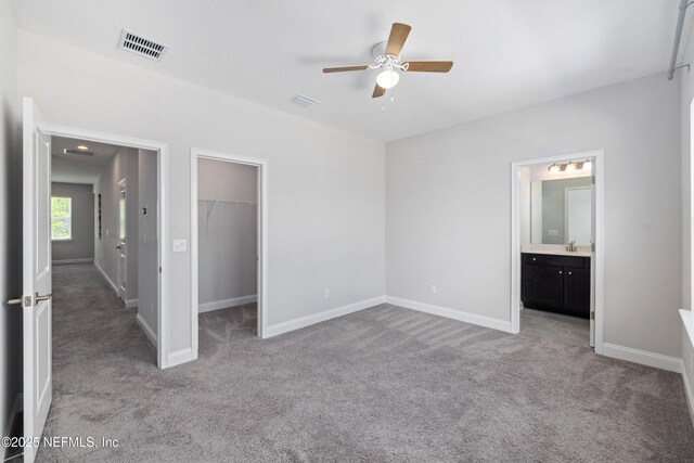 238 Courtney Chase Dr, Saint Augustine, FL 32092 - unfurnished bedroom featuring light carpet, a walk in closet, a closet, connected bathroom, and ceiling fan