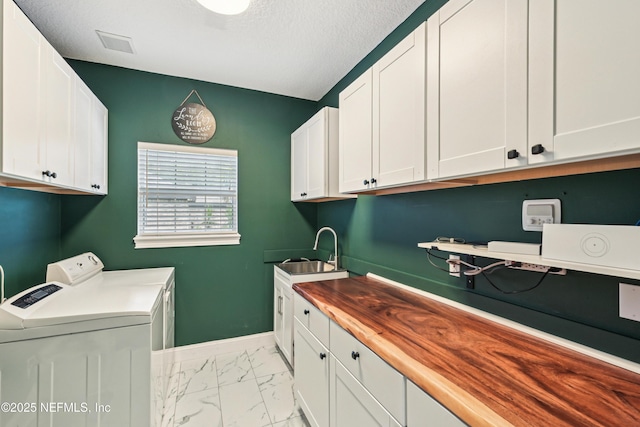 1288 Creek Bend Rd, Saint Johns, FL 32259 - washroom with separate washer and dryer, light marble finish floors, cabinet space, and a textured ceiling