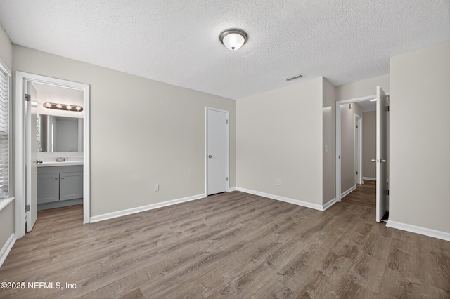 1359 Cove Landing Dr, Jacksonville, FL 32233 - unfurnished bedroom with light wood-type flooring, a textured ceiling, and ensuite bathroom