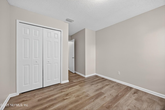 1359 Cove Landing Dr, Jacksonville, FL 32233 - unfurnished bedroom with wood finished floors, a closet, and a textured ceiling