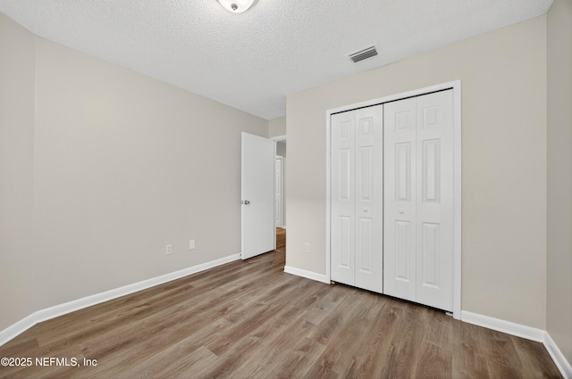 1359 Cove Landing Dr, Jacksonville, FL 32233 - unfurnished bedroom featuring wood finished floors, a closet, and a textured ceiling