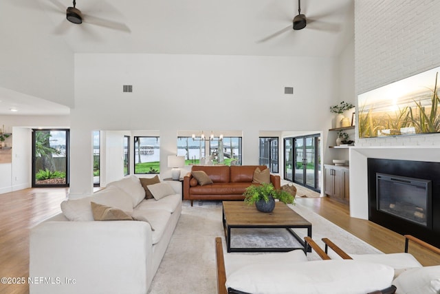 1823 N Lakeshore Dr, Fleming Island, FL 32003 - living room with ceiling fan, a towering ceiling, a large fireplace, and light wood-type flooring
