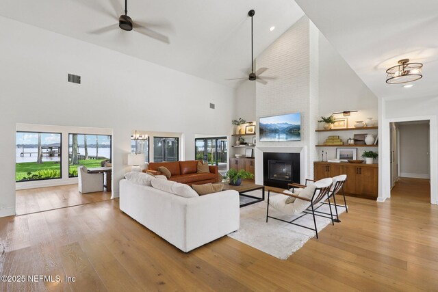 1823 N Lakeshore Dr, Fleming Island, FL 32003 - living room with high vaulted ceiling, a ceiling fan, light wood-type flooring, a fireplace, and recessed lighting
