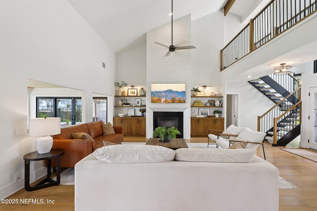 1823 N Lakeshore Dr, Fleming Island, FL 32003 - living area with stairs, light wood-type flooring, high vaulted ceiling, ceiling fan, and a glass covered fireplace