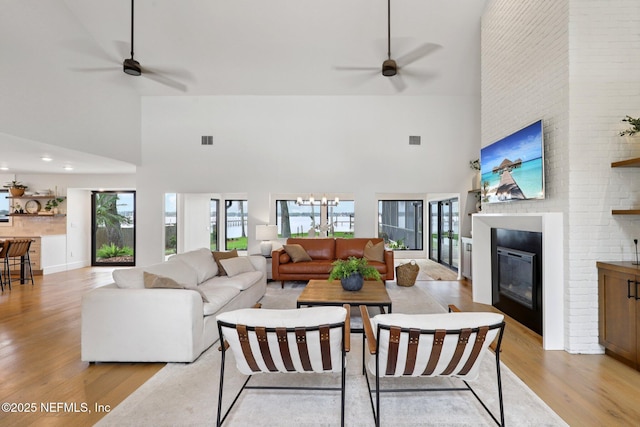1823 N Lakeshore Dr, Fleming Island, FL 32003 - living area featuring a towering ceiling, a ceiling fan, light wood-type flooring, and a large fireplace