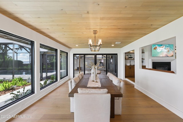 1823 N Lakeshore Dr, Fleming Island, FL 32003 - dining area with wooden ceiling, a chandelier, a fireplace, built in shelves, and wood finished floors