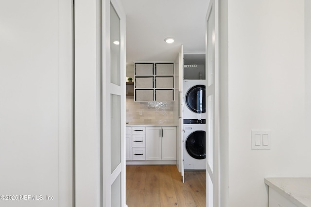 1823 N Lakeshore Dr, Fleming Island, FL 32003 - laundry room featuring stacked washer / drying machine, light wood finished floors, recessed lighting, and cabinet space