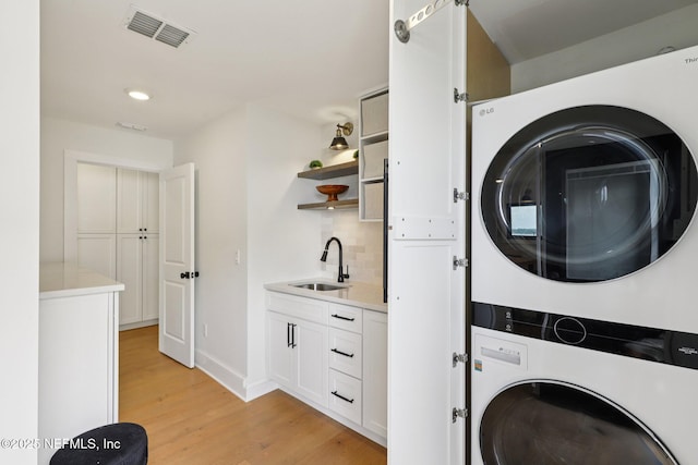 1823 N Lakeshore Dr, Fleming Island, FL 32003 - laundry room with stacked washer / dryer, light wood-type flooring, and recessed lighting