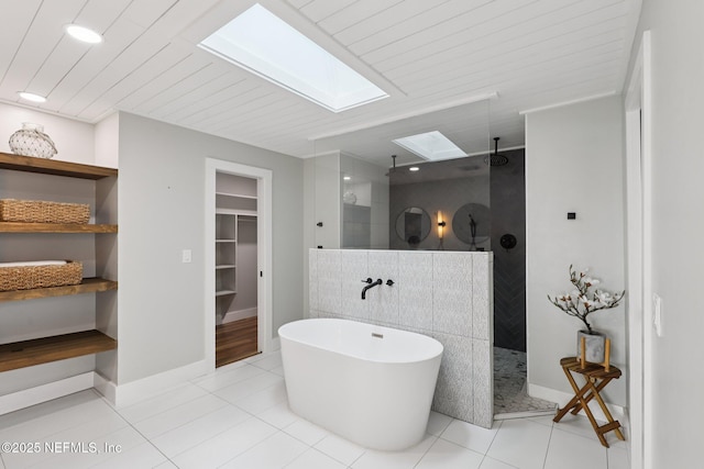 1823 N Lakeshore Dr, Fleming Island, FL 32003 - bathroom featuring a skylight, walk in shower, a freestanding tub, a spacious closet, and tile patterned flooring