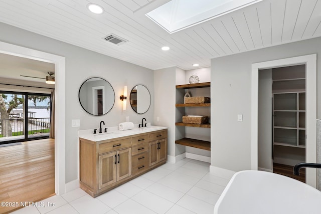 1823 N Lakeshore Dr, Fleming Island, FL 32003 - full bathroom featuring a skylight, double vanity, a freestanding bath, recessed lighting, and wooden ceiling