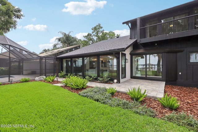 1823 N Lakeshore Dr, Fleming Island, FL 32003 - rear view of property with a lawn, roof with shingles, a patio, glass enclosure, and a sunroom