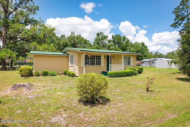 37206 Cypress Ln, Hilliard, FL 32046 - ranch-style house featuring a front yard, a porch, and a metal roof