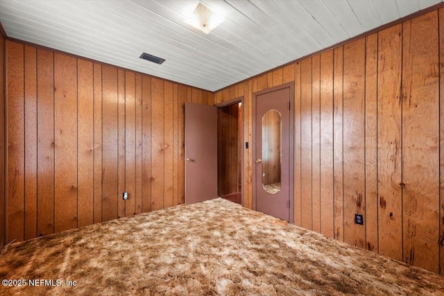 37206 Cypress Ln, Hilliard, FL 32046 - unfurnished bedroom featuring wooden walls and carpet flooring