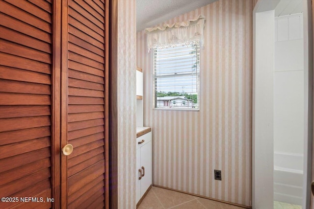 37206 Cypress Ln, Hilliard, FL 32046 - bathroom with vanity, tile patterned flooring, wallpapered walls, and a closet